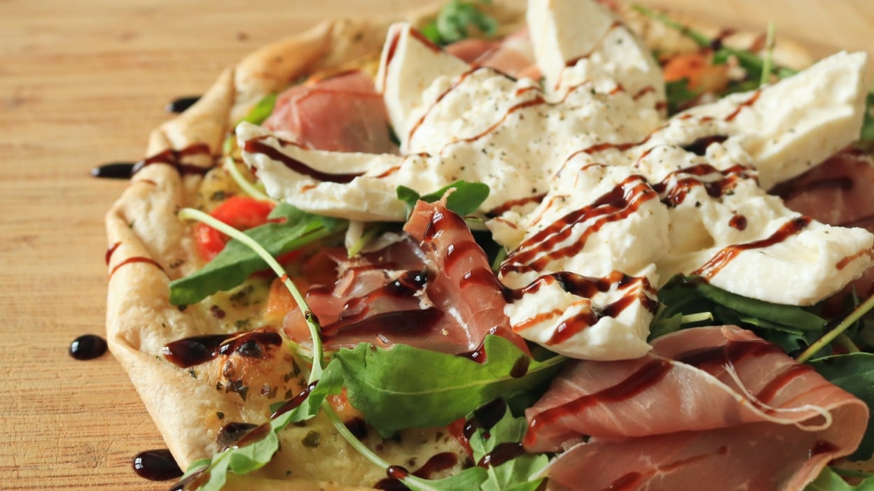 Pizza with burrata on top and some balsamic glaze.