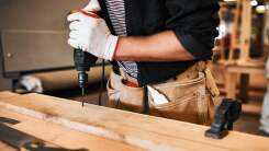 Man using a drill on a piece of wood