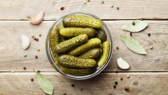 Pickles in a bowl on a wooden table.