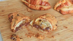 Croissant stuffed with cookie dough cut in half on a cutting board