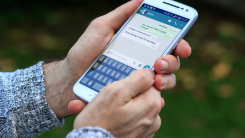 person holding smartphone with whatsapp on screen