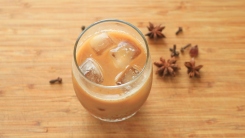 Cold brew coffee on a cutting board with whole spices.