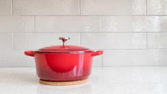 A red Dutch oven on a white countertop.