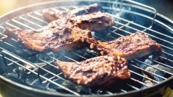 Steaks on a charcoal grill.