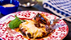 Eggplant parmesan on a red and white plate.