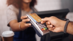 woman handing card to cashier 