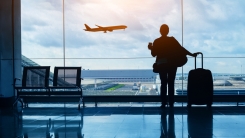 Silhouette of woman in airport watching plane take off