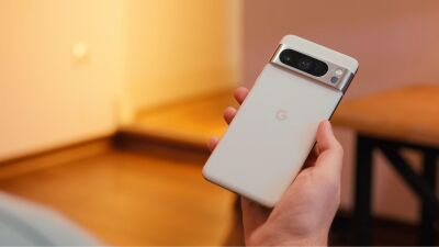 A hand holding a white google pixel smartphone