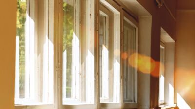 Bright rays of sun streaming through curtainless windows