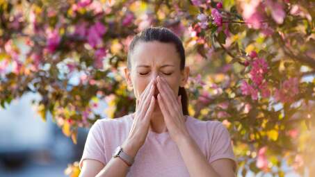 person sneezing amongst flowers