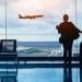 Silhouette of woman in airport watching plane take off