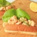 Two shrimp rolls on a cuttingboard.