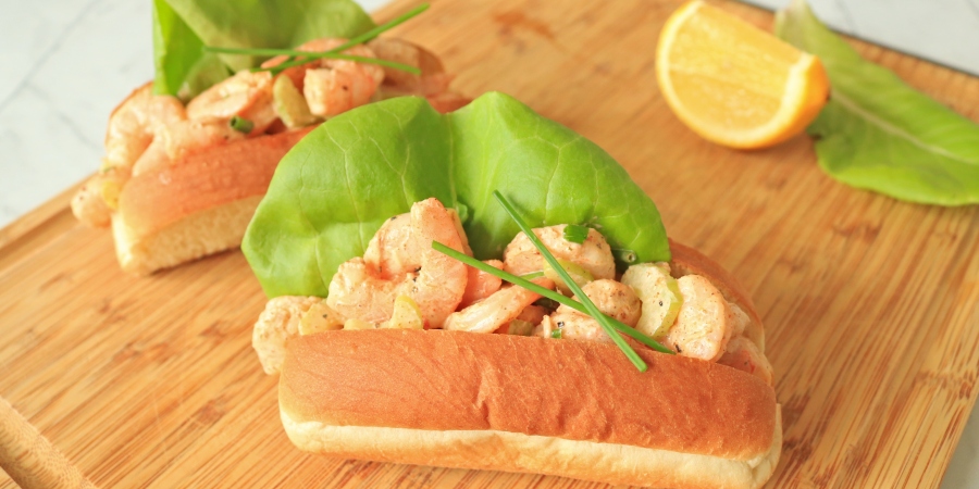 Two shrimp rolls on a cuttingboard.