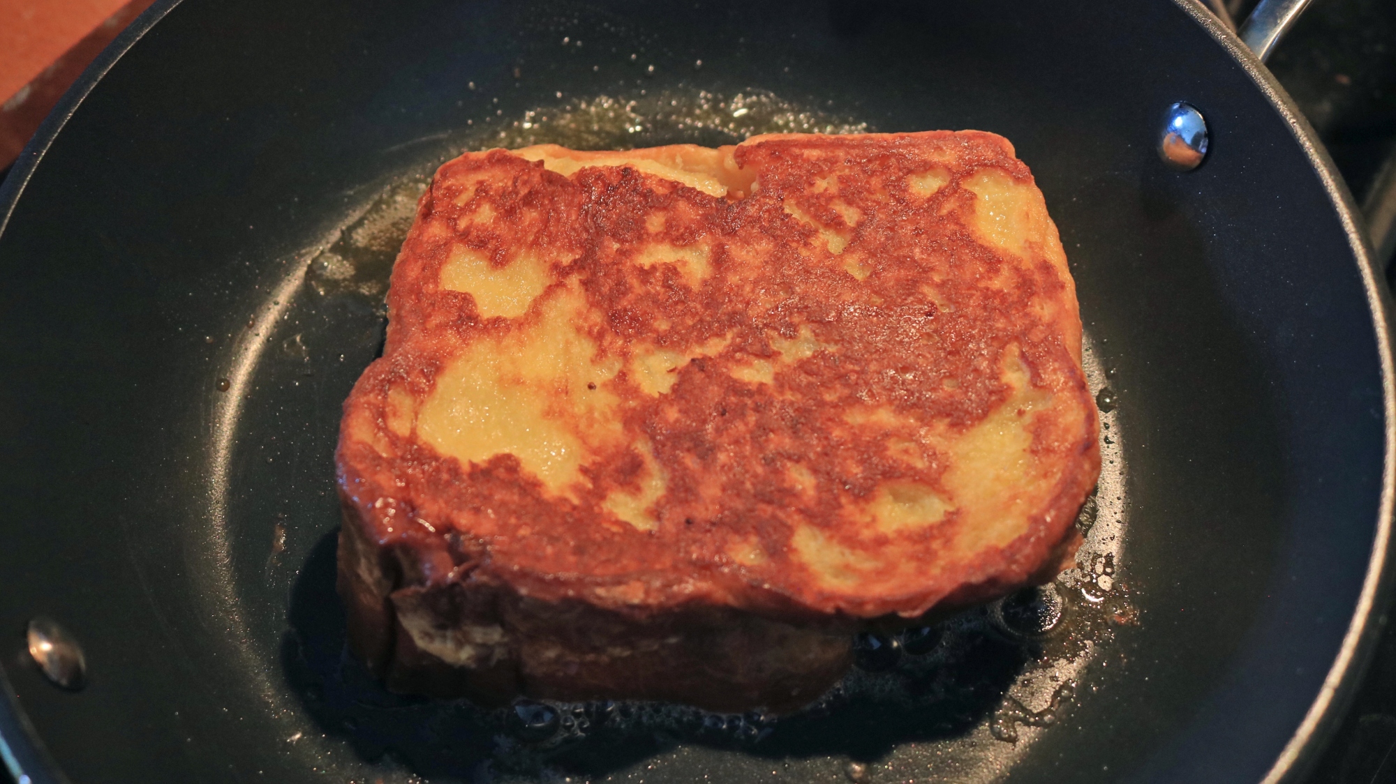 French toast frying in a frying pan.