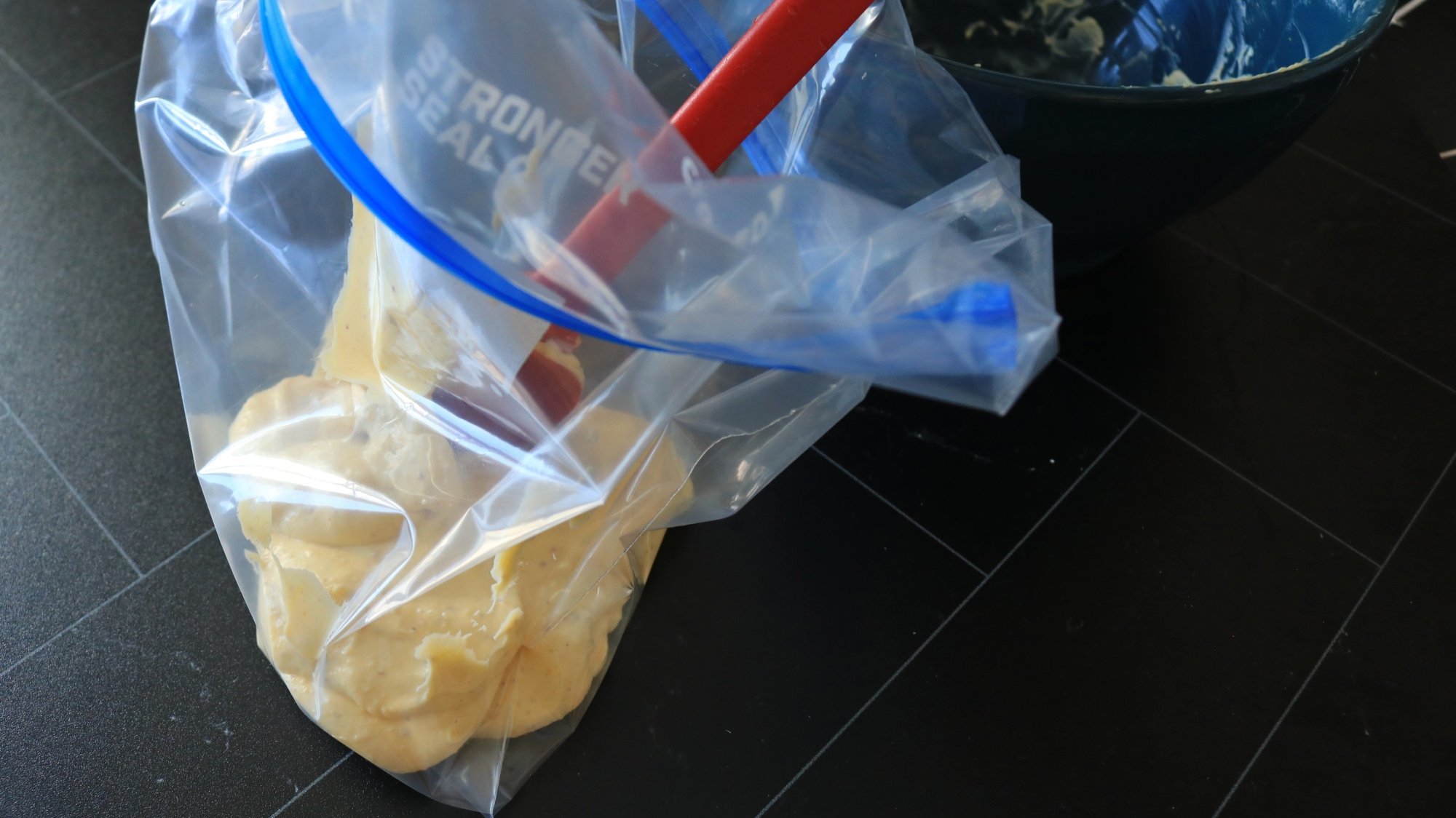 A plastic bag getting filled with yellow filling.