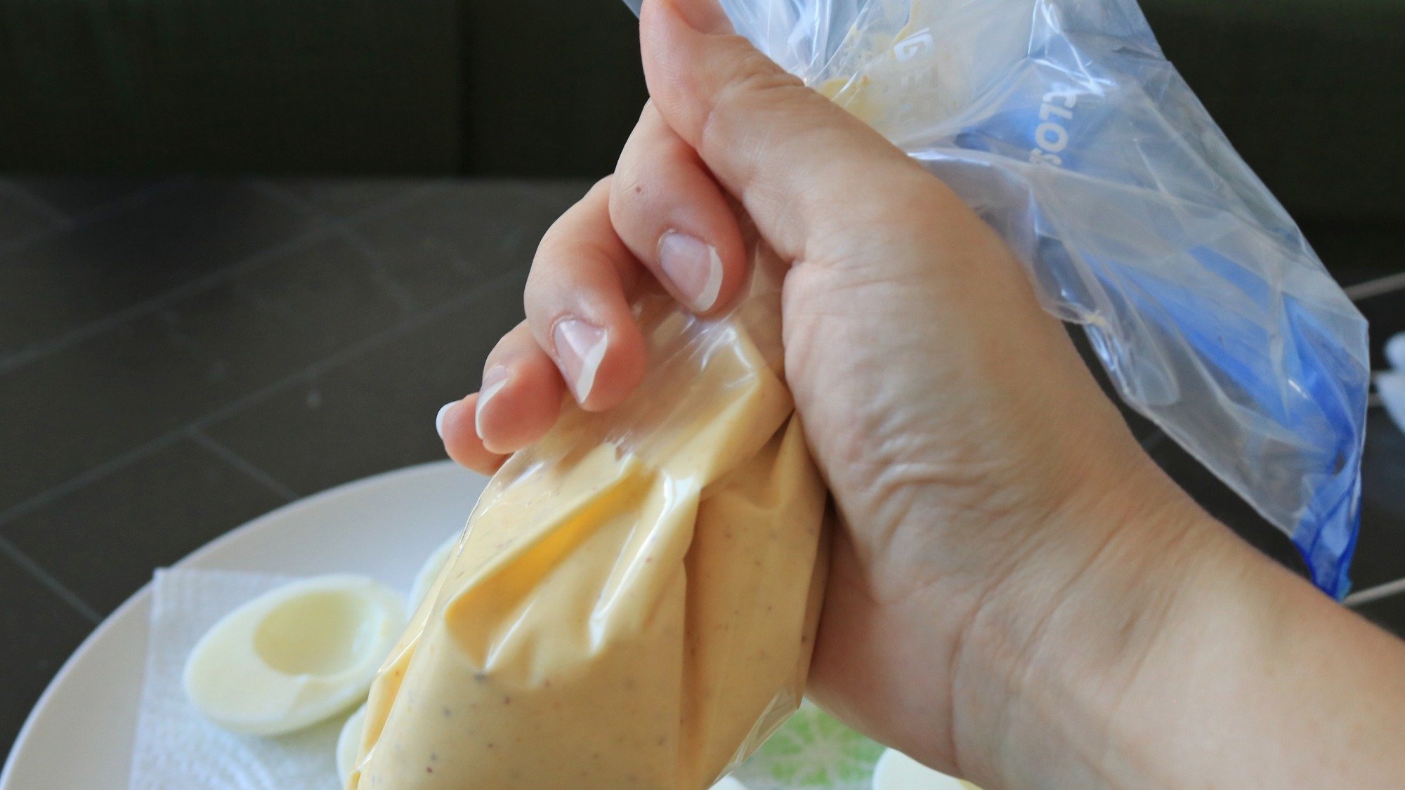 A hand holding a plastic bag with filling.