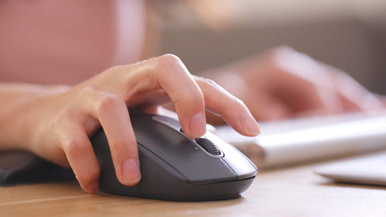 A person with a raised finger about to press the middle mouse button