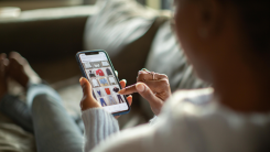 woman shopping for clothing online on smartphone