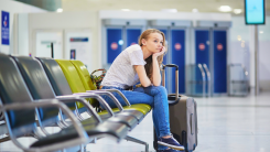 Young woman waits at airport gate.