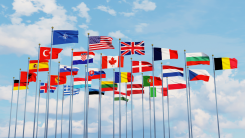 A collection of a few dozen flags from countries around the world flying in a group