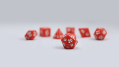 A red D20 polyhedral die with other dice on the background