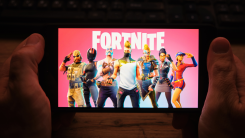 person holding smartphone with fortnite on screen