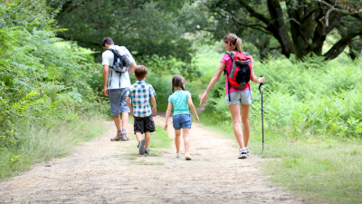 family of four hiking together through a park