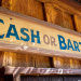 old-fashioned wooden sign that reads "cash or barter"