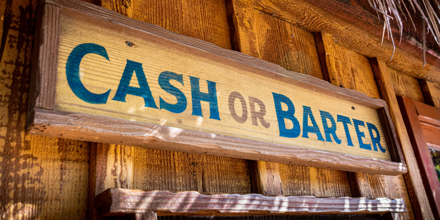 old-fashioned wooden sign that reads "cash or barter"