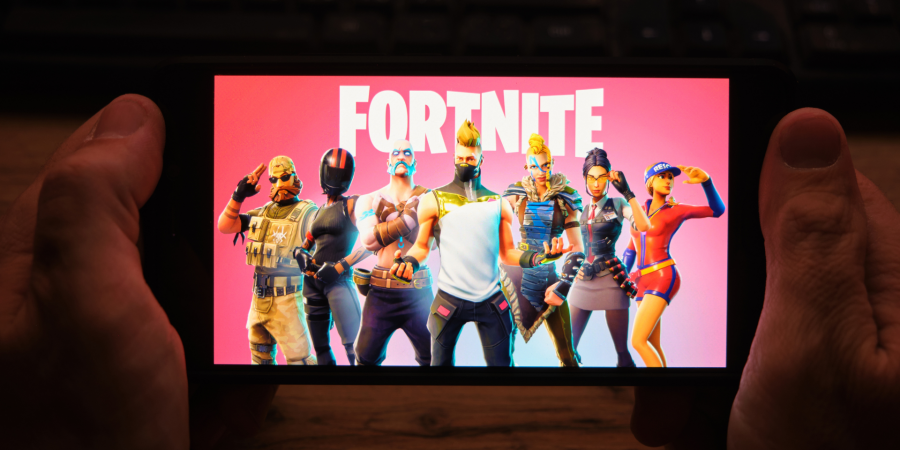 person holding smartphone with fortnite on screen