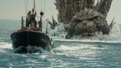 Godzilla chases a boat in a still from Godzilla Minus One